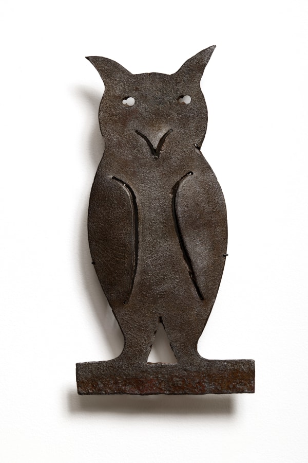 Architectural Owl Form, ca. 1930-40 Sheet iron (custom wall mount) 16 x 8 1/2 x 1/2 in. (40.6 x 21.6 x 1.3 cm) (ArU 509) SOLD &bull;&bull;&bull; Cut from a single plate of sheet iron, this stylized owl feels at once like an emblem and a guardian. Its form is reduced to a few decisive cuts&mdash;the wide ears, almond body, and incised wings&mdash;so that the entire creature hovers somewhere between hieroglyph and street sign. The punched eyes and beak carve out a calm, almost quizzical expression, an alert stillness that suggests it once watched over a doorway, cornice, or threshold. Time has worked its way across the surface, leaving a rich, weathered patina that deepens the sense of quiet authority. Stripped of its original architectural context, the piece now reads as a compact, self-contained presence: part sentinel, part symbol, and an unmistakable character in its own right.