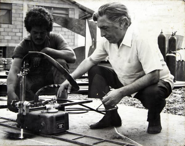 Amilcar de Castro recortando a chapa de metal em seu ateliê em 1960.