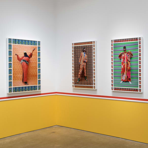 Installation View | Hassan Hajjaj: My Rockstars  Featured Artworks:  Hassan Hajjaj (Moroccan, b. 1961)  Man Bellydancer, 2012/1433 (Gregorian/Hijri)  Metallic Lambda on 3mm Dibond in a Poplar Sprayed-White Frame with Blue Taous Mint Tea Boxes  Image: 44" x 30" (112 x 76 cm)  Framed: 57 1/4" x 39 3/4" x 2 3/4" (145.5 x 101 x 7 cm)  Signed, Titled, Dated and Numbered Verso in Ink  Edition of 5 + 2 Artist’s Proofs  Hassan Hajjaj (Moroccan, b. 1961)  Seye Adelekan, 2012/1433 (Gregorian/Hijri)  Metallic Lambda on 3mm Dibond in a Poplar Sprayed-White Frame with Small Olla Tomato Cans  Image: 44" x 30" (112 x 76 cm)  Framed: 52 1/2" x 37" x 2 1/2" (133.5 x 94 x 6.5 cm)  Signed, Titled, Dated and Numbered Verso in Ink  Edition of 5 + 2 Artist’s Proofs  Hassan Hajjaj (Moroccan, b. 1961)  Mimz, 2013/1434 (Gregorian/Hijri)  Metallic Lambda on 3mm Dibond in a Poplar Sprayed-White Frame with Small Soraya Tomato Cans  Image: 44" x 30" (112 x 76 cm)  Framed: 52 3/8" x 36 7/8" x 2 1/2" (133 x 93.5 x 6.5 cm)  Signed, Titled, Dated and Numbered Verso in Ink  Edition of 5 + 2 Artist’s Proofs