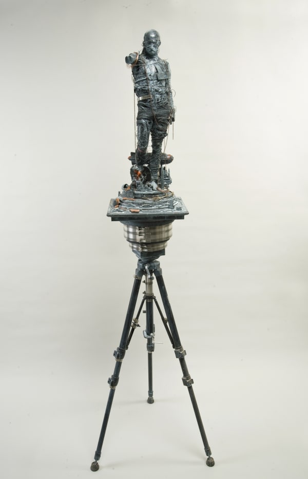Bob Lewis sculpture of a man wrapped in wire on a tripod using metal, wood, plaster.