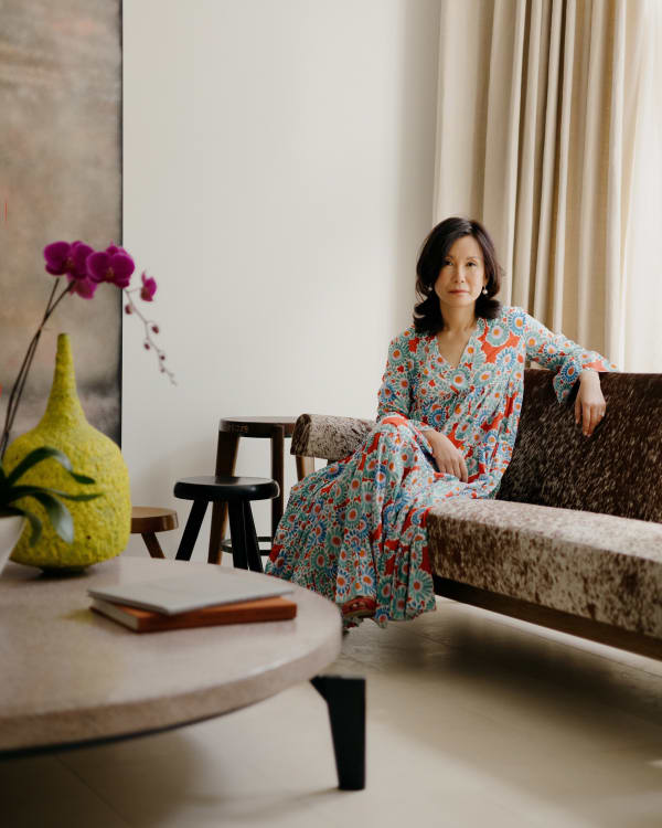 Tina Kim in her living room, which features a painting by Sterling Ruby, a Jean Prouvé coffee table, a Pierre Jeanneret sofa, and Charlotte Perriand stools. Photo: William Jess Laird.