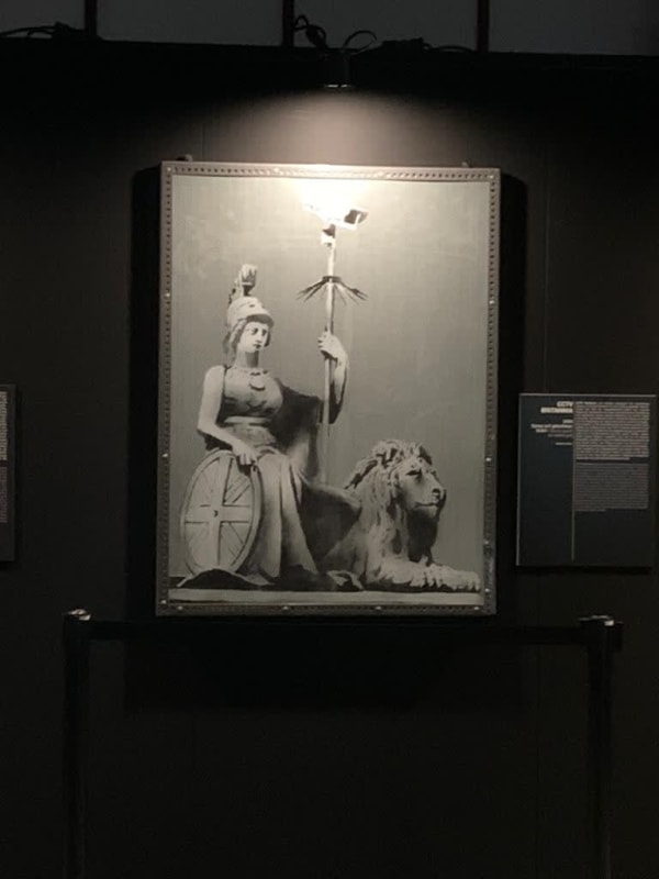 Banksy artwork hanging on wall