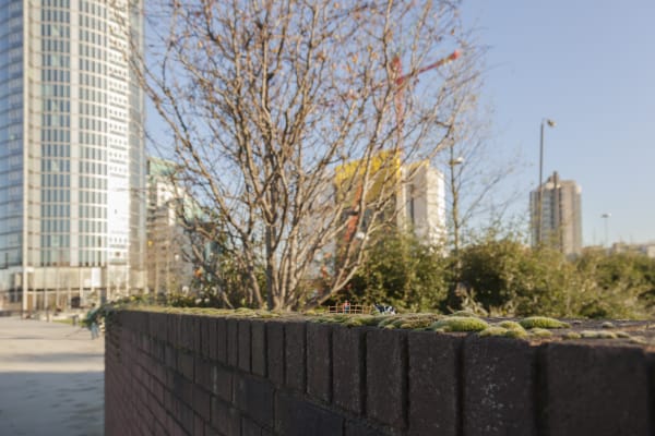 Slinkachu Gods green earth context shot (on a fence)