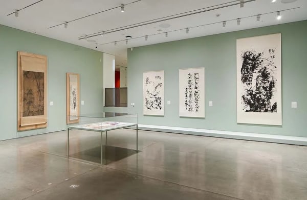 Exhibition view at BAMPFA, featuring ink paintings and calligraphy on the two walls