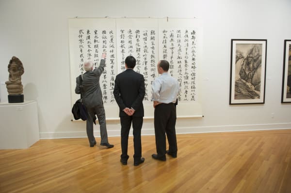 A group of men looking at a painting