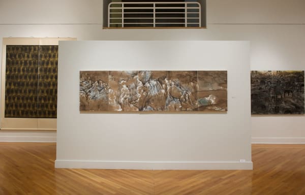 A five-screen landscape painting with brown tones and green-blue mountains hanging in the museum display