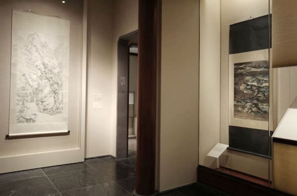On the left is hanging a landscape scroll with lines by arnold, and on the right is hanging a work by c.c.wang