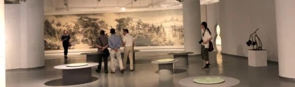 A group of people in a room looking at a painting