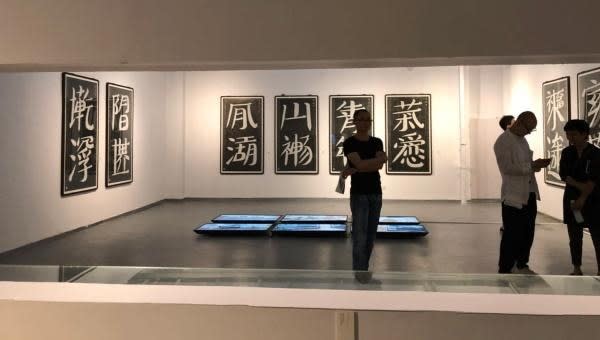 A person standing in a room with art on the wall