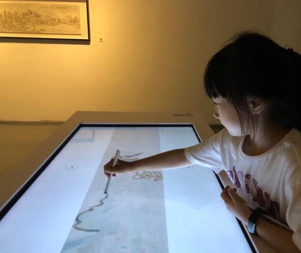 A child drawing on a touch screen