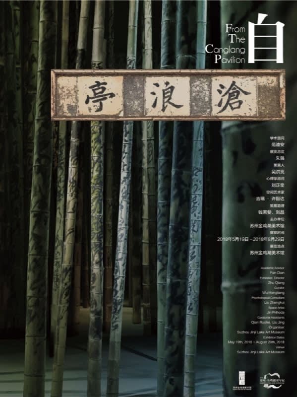 An exhibition poster with a plaque hanging in front of a bamboo forest