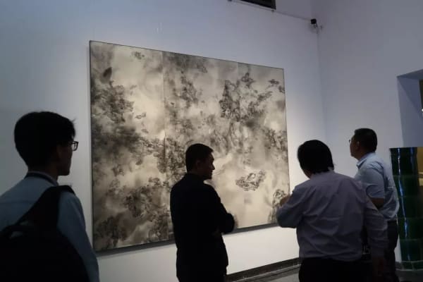 A group of people looking at a painting