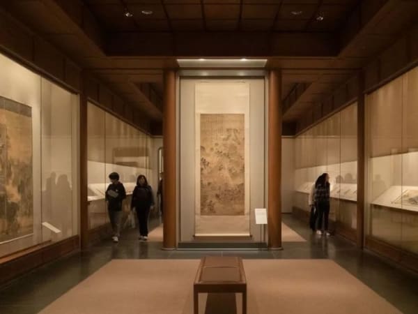 The museum's exhibition hall, with a long display case in the middle and transparent display tables on either side that also hold scrolls