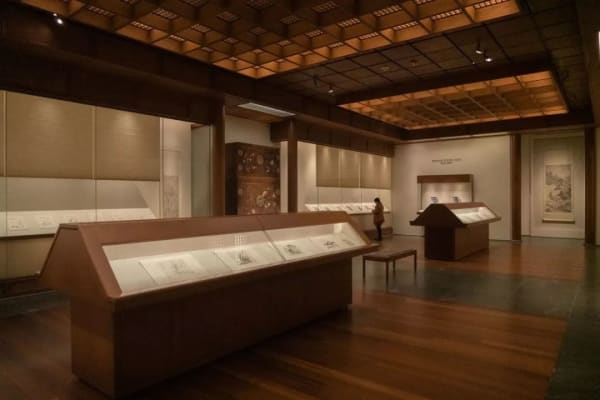 The museum's exhibition hall, with a long display case in the middle and transparent display tables on either side that also hold scrolls
