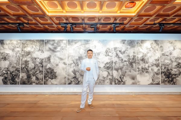 tai xiangzhou standing in front of his work