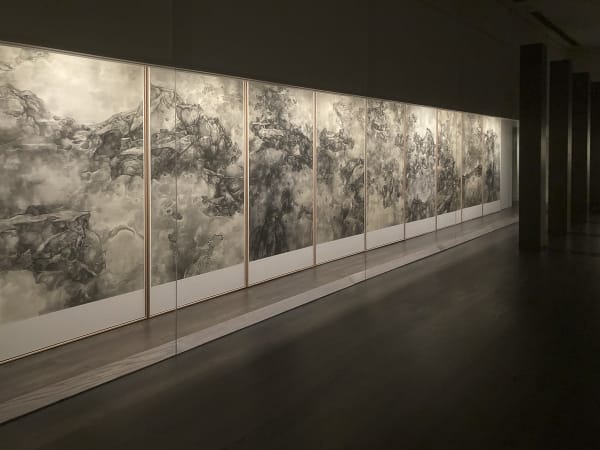 A dark-toned exhibition hall with works by tai xiangzhou on both sides