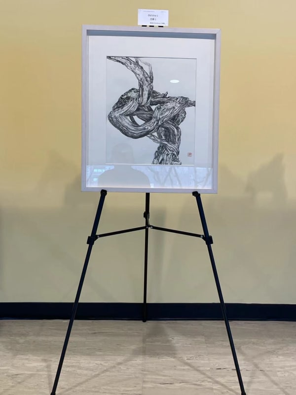 an artwork with black cirrus depicted on a piece of white paper, exhibiting on a tripod stand