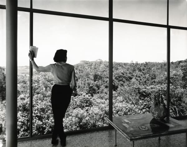 Lina Bo Bardi at the Glass House window. Photo: Francisco Albuquerque/Instituto Bardi.