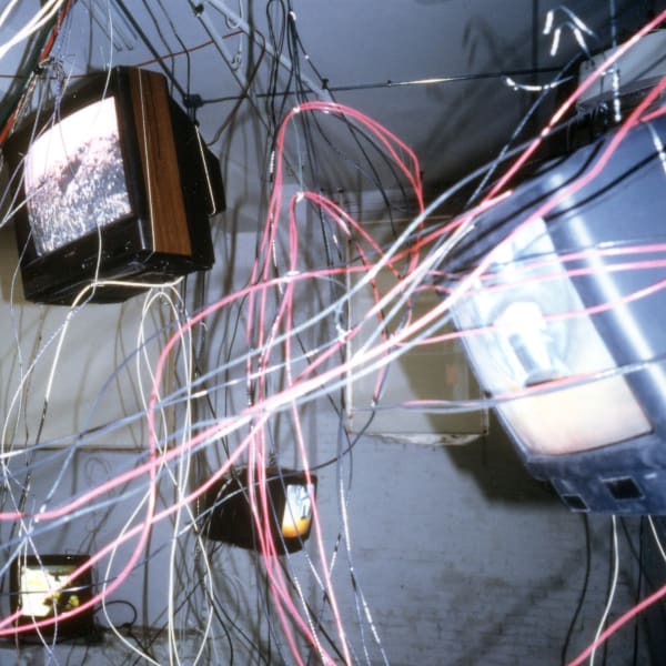Carolee Schneemann, More Wrong Things, 2001, Fourteen video monitors with video loops suspended from the ceiling within an extended tangle of wires, cables, and cords, Dimensions vary with installation