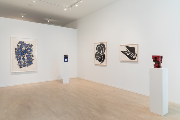 A grouping of Mel Kendrick's and Jack Youngerman's: two Jack Youngerman drawings on the right wall, three Mel Kendrick sculptures interspersed throughout, and one Mel Kendrick painting hung on the adjacent wall to the left.