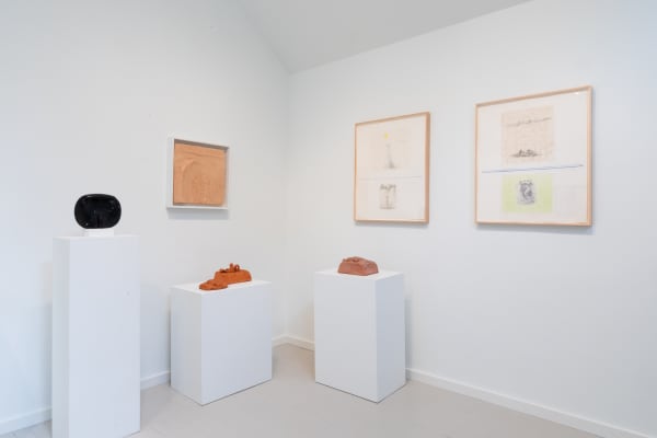 A group of Costantino Nivola clay reliefs, drawings, and clay and marble sculptures on plinths.