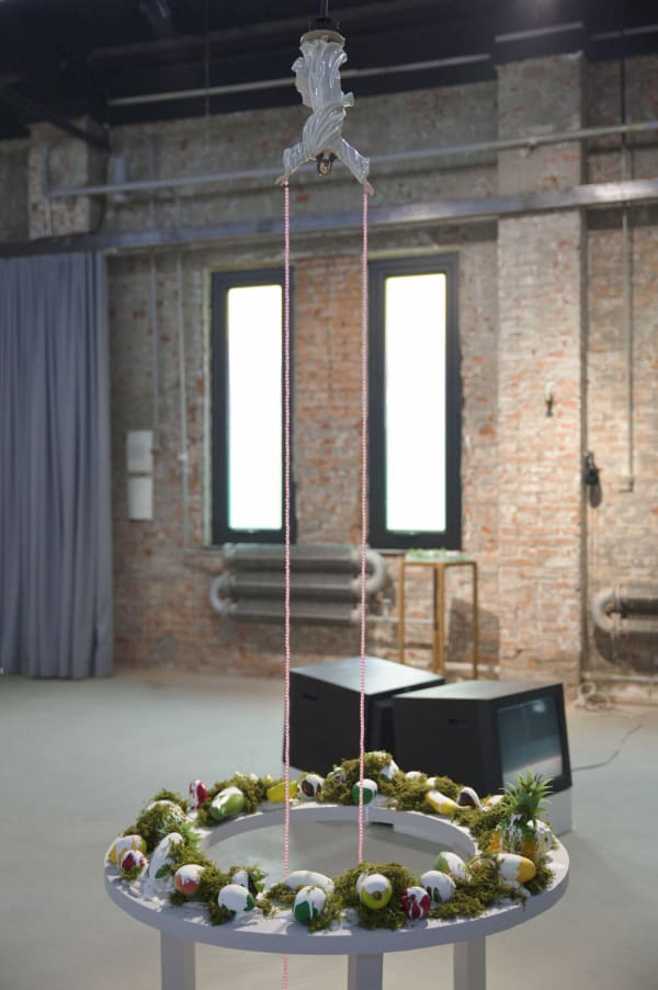 "Dazed”, Chen Dandizi, 2020, Jesus statue, stainless steel bracket, colorful plastic beads, transparent fishing thread, wood board, plastic fruit, paint, artificial moss, soil, rubber slippers made in Vietnam, variable dimensions, courtesy of the gallery and the artist.