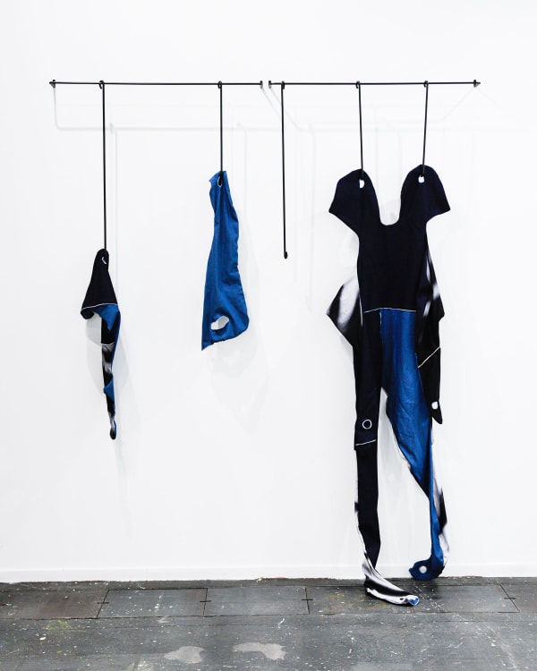 FannyGicquel,theskinsfrom other, 2022, steel, painting, printed cotton fabric, blue jean,variabledimension(systemto hanging in steel is 100x15 cm). Courtesy of the artist and Hua International Booth designed by Krista Xueying Yu