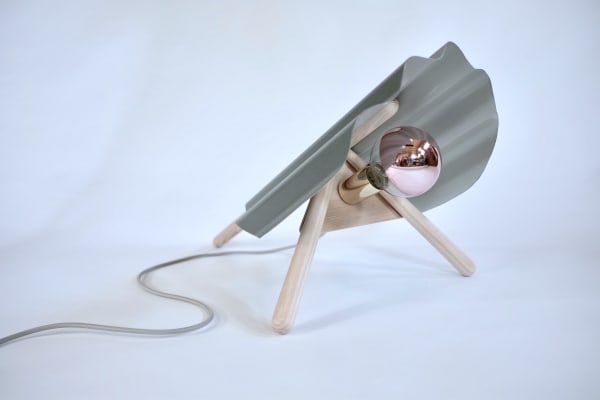 A handmade surface lamp, a corrugated tin upper sits upon handturned ash legs with a semi exposed oversize copper reflective bulb.
