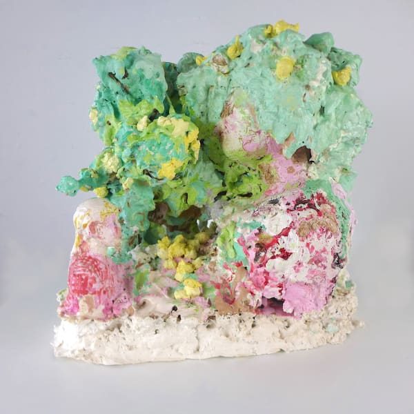 A plaster sculpture of a green tree with yellow apples, a small fence at the back and a young girl looking up at a woman with hidden face