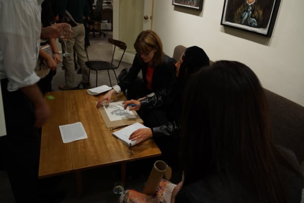  Photograph of Sue Coe and gallery visitors at the opening of the exhibition "Mad as Hell," 2012