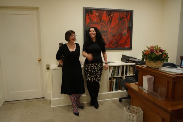 Photograph of gallery staff members Courtney Donner and Fay Duftler sharing a laugh at the opening of Sue Coe's "Mad as Hell," 2012