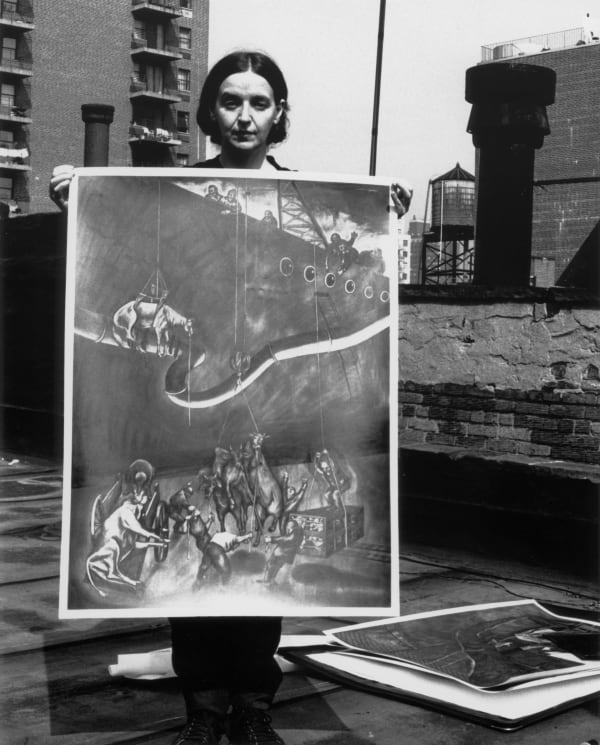 Black and white picture of artist Sue Coe standing on a rooftop, holding a painting of an animal rights work in 1985