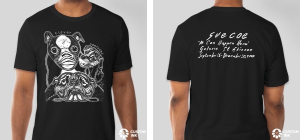 Front and back of t-shirt show; on the front, there are three dogs: one wearing a mask (text reads: clever), one half-wearing a mask (confused), and one not wearing a mask at all. The back has the name of the exhibition "It Can Happen Here, " along with t