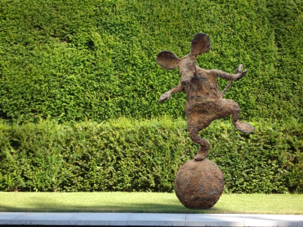 Bronze mouse balancing on a ball garden sculpture