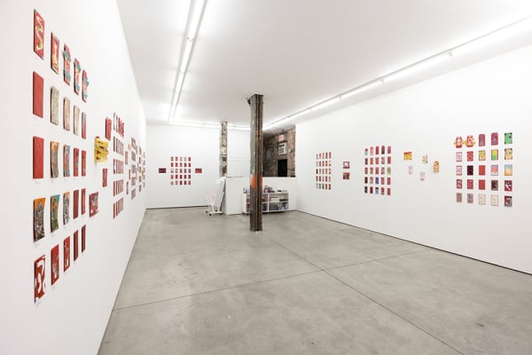 installation photograph of lunar new year red envelopes hung on a white wall 