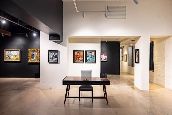 Artwork displayed in art gallery on black and white walls.