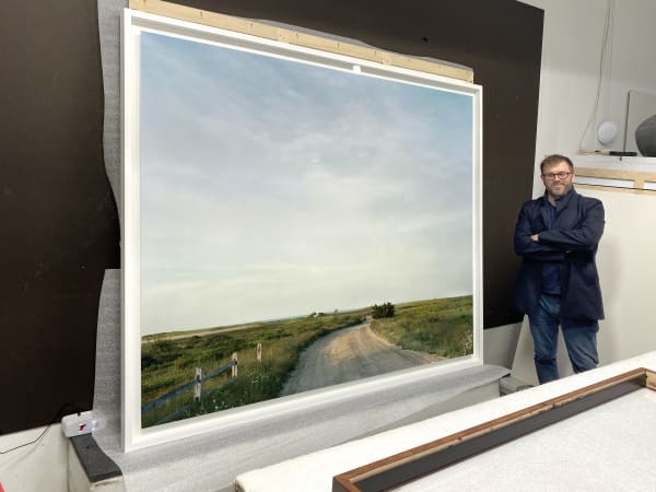 GAILLARD STANDING NEXT TO A FINISHED 74 X 86 INCH PIECE WITH THE MOUNTED PIECE FLOATED WITHIN THE FRAME