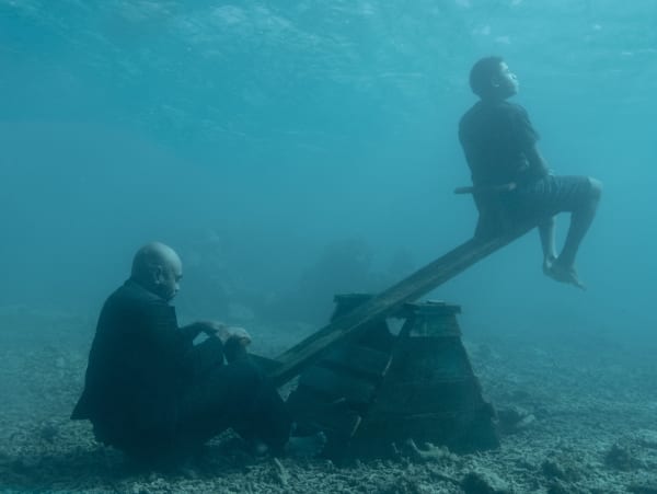 Man and boy sit on a seesaw underwater photography by Nick Brandt from his SINK/RISE series