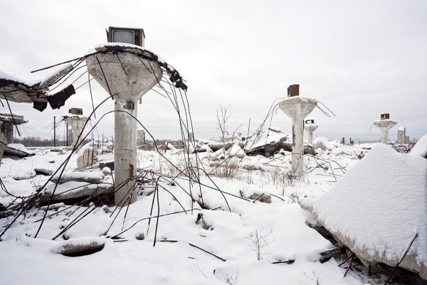 Photo by artist Scott Hocking. Three large pillars outside with bent wires and old televisions covered in snow.