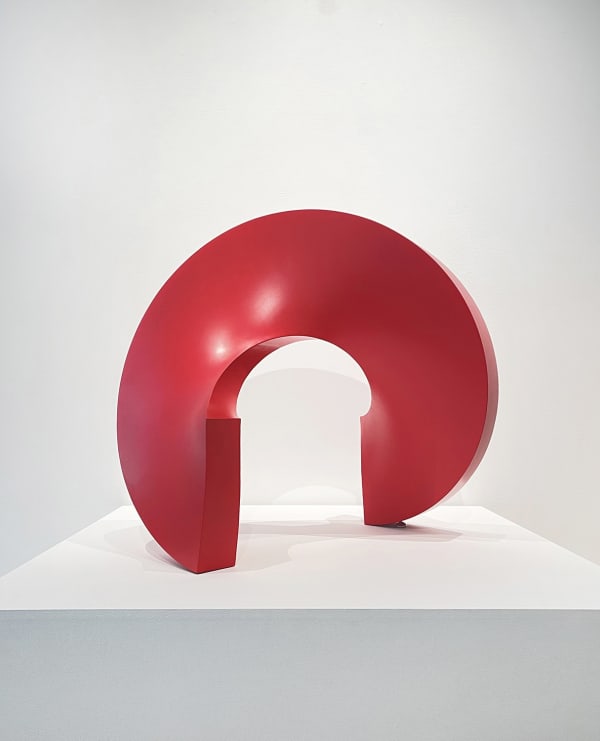 Round abstract sculpture that sits on a square base