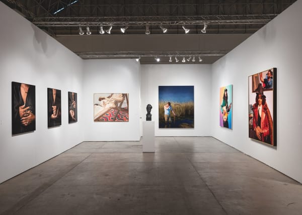 Installation view of gallery's booth at Expo Chicago art fair. The booth shows several figurative paintings hanging on the wall.