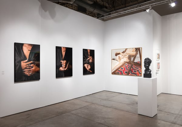 Installation view of gallery's booth at Expo Chicago art fair. The booth shows several figurative paintings and photographs hanging on the wall.