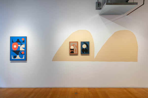 Close-up view of the left wall. On the left hangs Visions Generally Have More Clarity Than Dreams, and on the right hang Pitch Bender and Modulation Wheel framed by a double-humped beige shape painted on the wall.