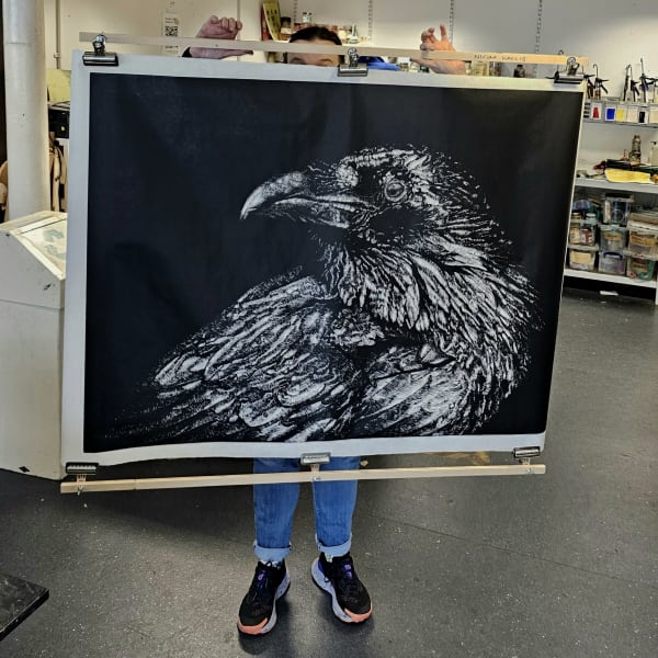 Dramatic Raven linocut print on a black background by Nicola Wallis
