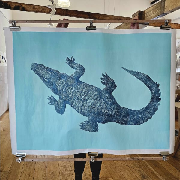 Linocut art print of a crocodile under blue water by Nicola Wallis