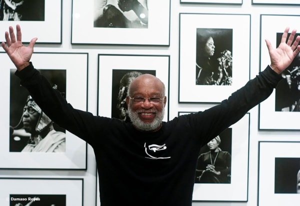 Photographer Chester Higgins Jr. poses in front of a few images from his Black Pantheon series. (Photo by Damaso Reyes)