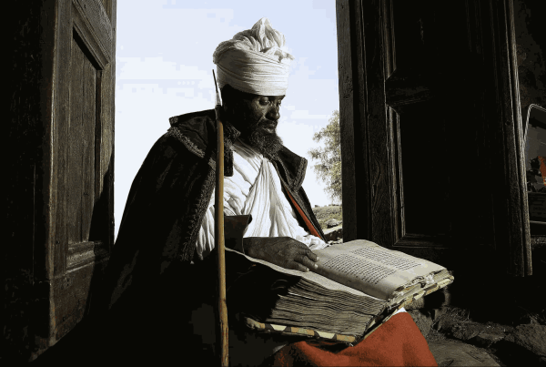 Priest of the Church of Naakute Laab reading from a vellum Bible in the Church doorway, Near Lalibela, Ethiopia, 2010 © Chester Higgins