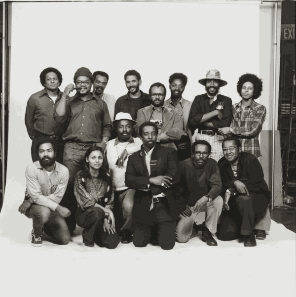 Anthony Barboza photographed “Kamoinge Members” in 1973. Back row, from left: Albert R. Fennar, Ray Francis, Herbert Randall, C. Daniel Dawson, Beuford Smith, Herb Robinson, Adger Cowans and Anthony Barboza. Front row, from left: Herman Howard, Ming Smith, James Mannas Jr., Louis Draper, Calvin Wilson and Shawn Walker.