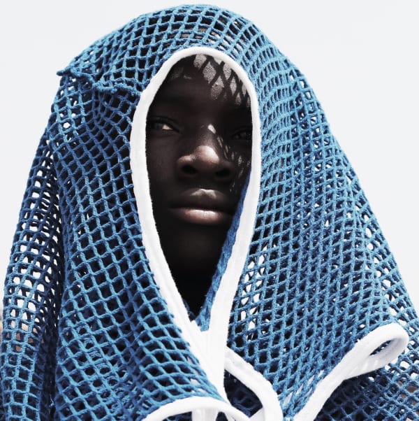 Photograph by Nana Yaw Oduro showing a man trying to hide underneath a sport jersey