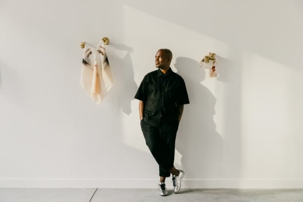 Jonathan Carver Moore stands between works by Kacy Jung, photo by Vita Hewitt